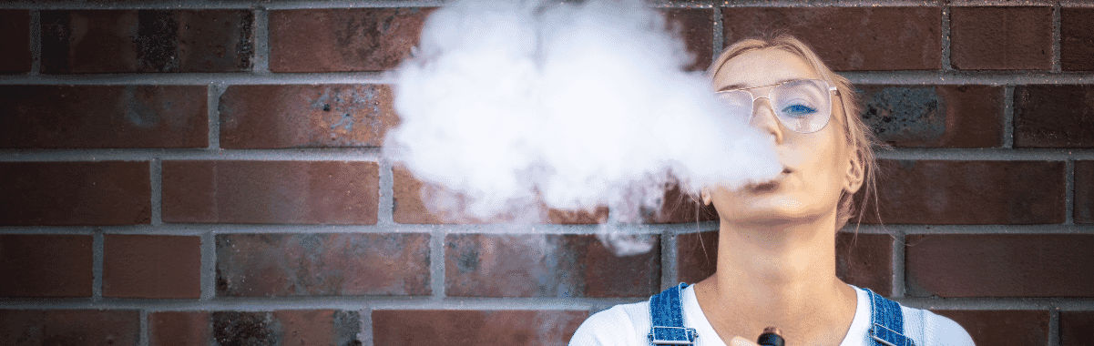 E-Cig User Vaping Against Brick Wall