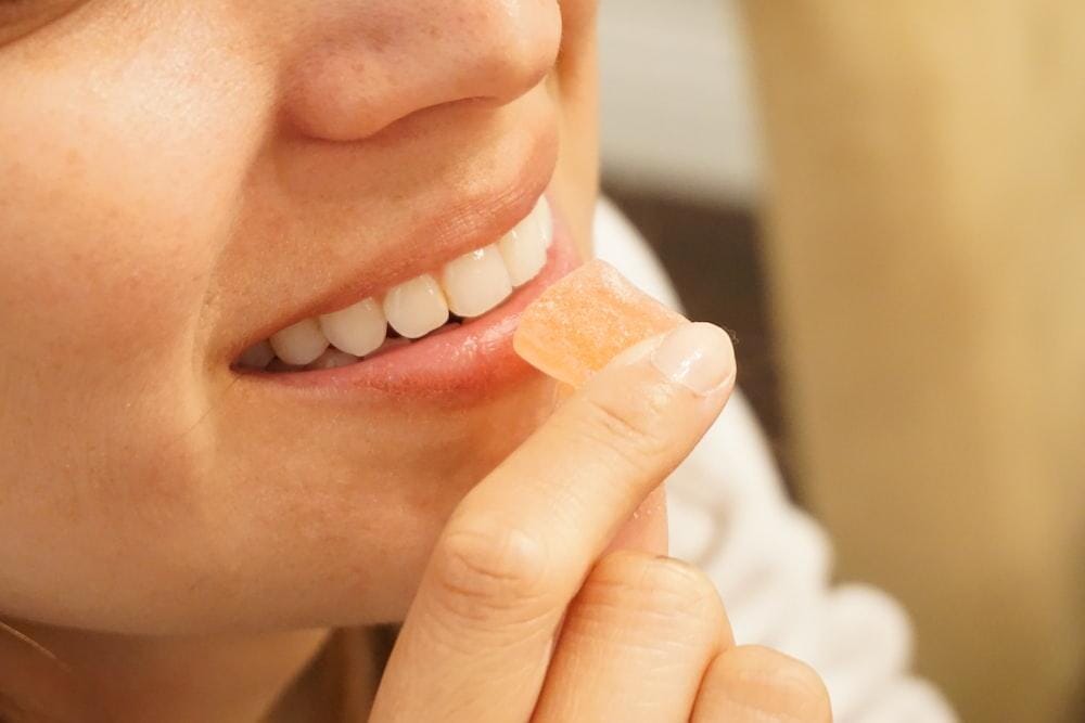 Woman Smiling and Eating a Cannabis Gummy